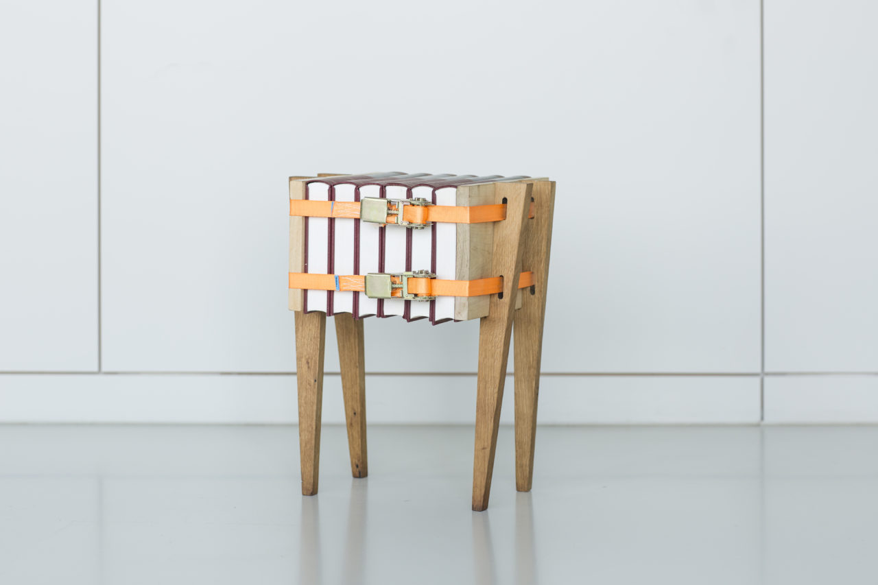 Bijzettafel Press Only. De spanbanden houden deze tafel bij elkaar. Boeken, kranten, of houtblokken kunnen er allemaal tussen geklemd worden.